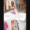 Britt Nicole walking on road holding bicycle beside her with "Britt Nicole Hanging on" overlay - My Christian Musician