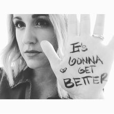Black and white image of Britt Nicole holding up her hand with "It's Gonna Get Better" and a heart shape on her hand - My Christian Musician