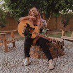 Jamie Grace poses with a guitar while sitting