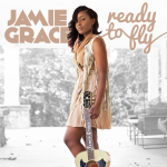 Jamie Grace stares at the camera while holding her guitar, with a text above her displaying "JAMIE GRACE, ready to fly" - My Christian Musician