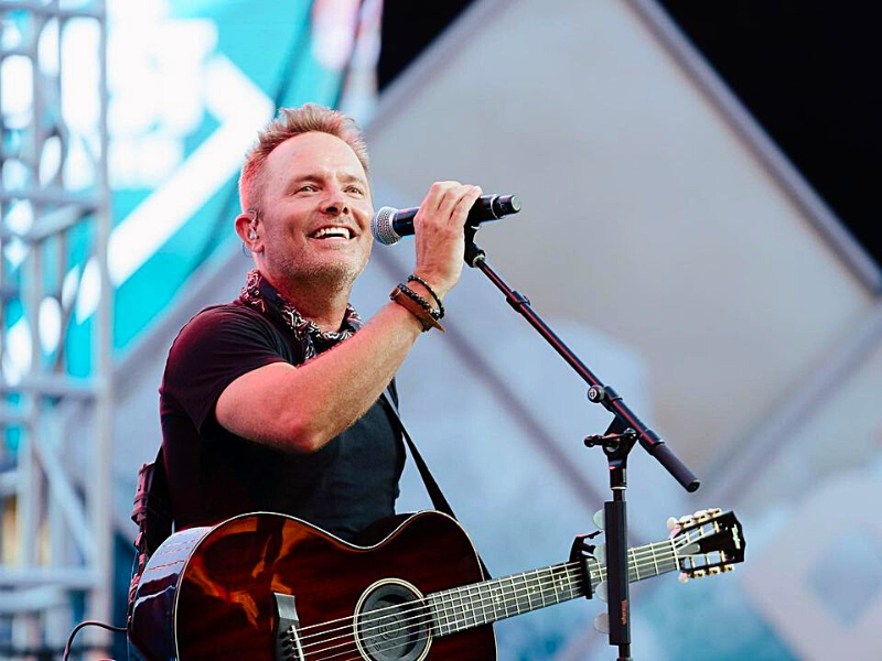 Chris Tomlin equipped with a guitar singing onstage at Indiana - My Christian Musician